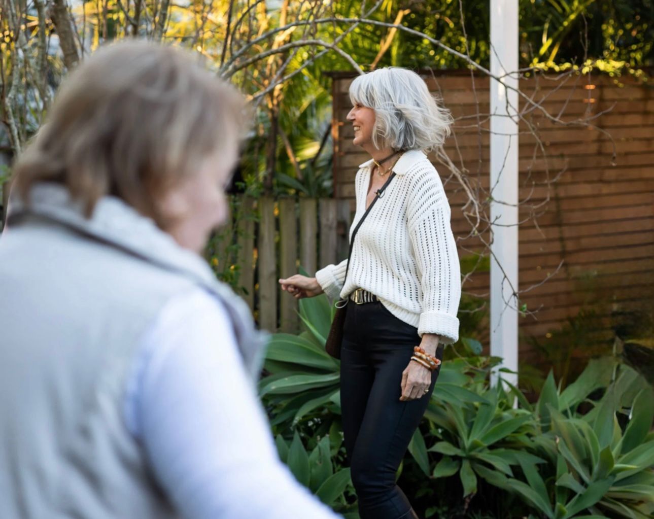 Ros Banksia-Smith walking and talking with a guest in a garden