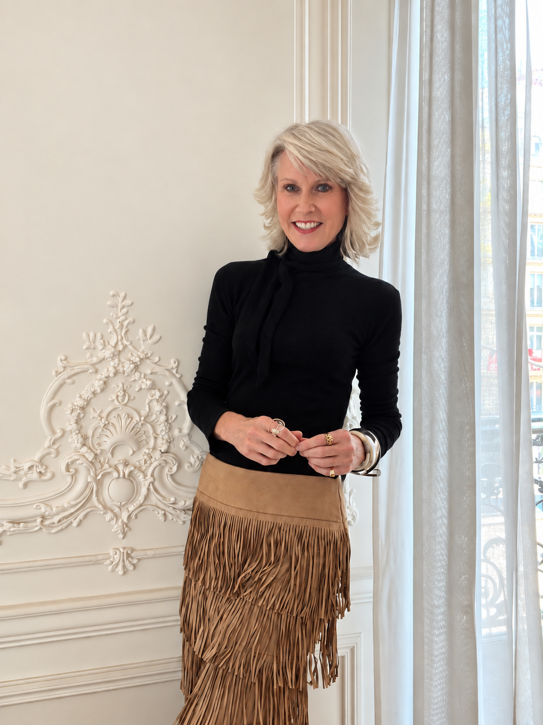 Ros Banksia-Smith standing beside a window in a classic Parisian apartment